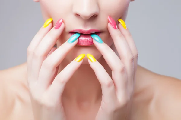 Gekleurde manicure, vrouw gezicht met regenboog make-up en manicure — Stockfoto