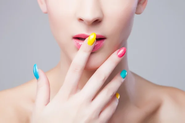 Manicura coloreada, cara de mujer con maquillaje de arco iris y manicura — Foto de Stock