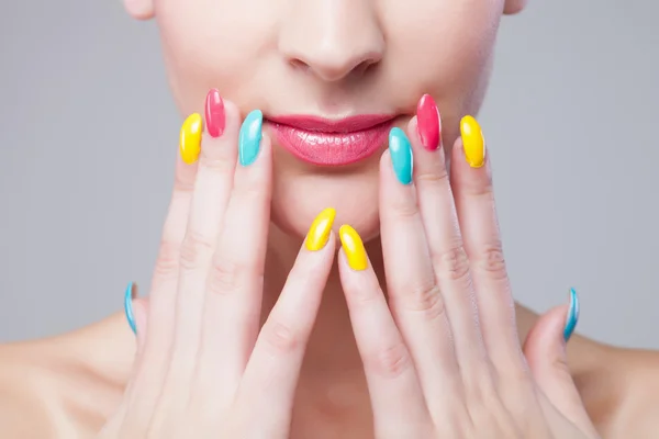 Manicura coloreada, cara de mujer con maquillaje de arco iris y manicura — Foto de Stock