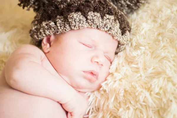 Belo bebê adormecido usando um chapéu listrado — Fotografia de Stock