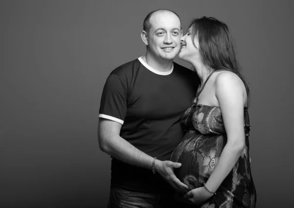 Gravidez jovem mulher com homem em estúdio — Fotografia de Stock