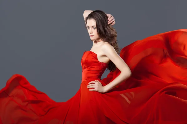 Sexy vrouw in wapperen rode jurk — Stockfoto