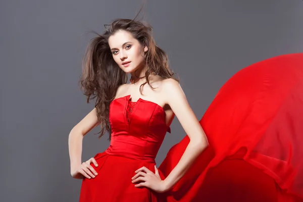 Σέξι γυναίκα στον φτερουγίσματα κόκκινο φόρεμα — Φωτογραφία Αρχείου