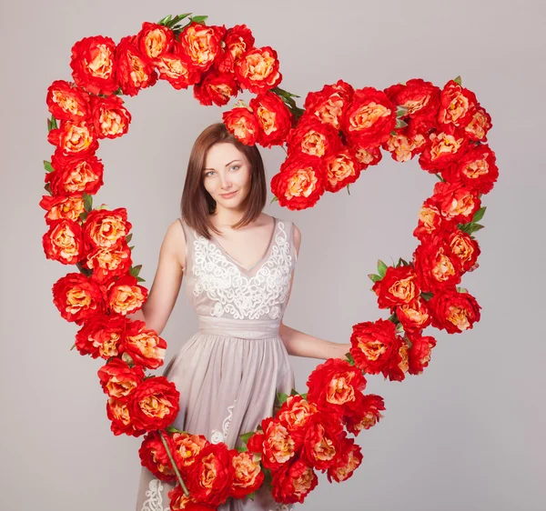 Beautiful woman with heart of flowers — Stock Photo, Image