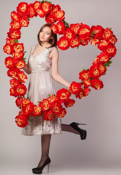 Beautiful woman with heart of flowers — Stock Photo, Image