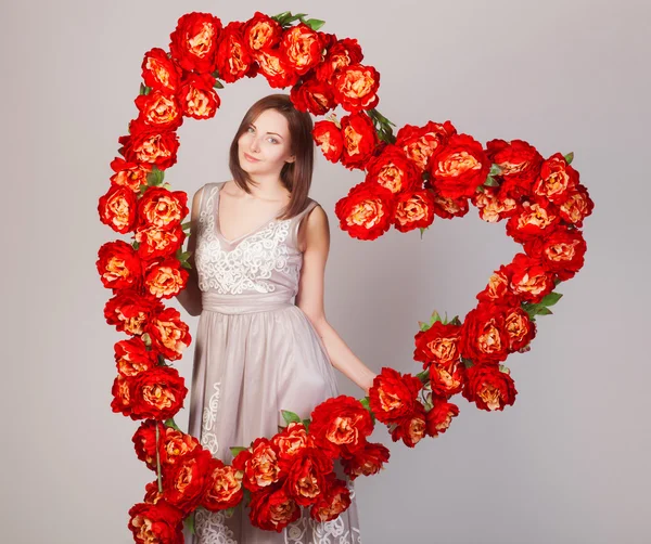 Beautiful woman with heart of flowers — Stock Photo, Image