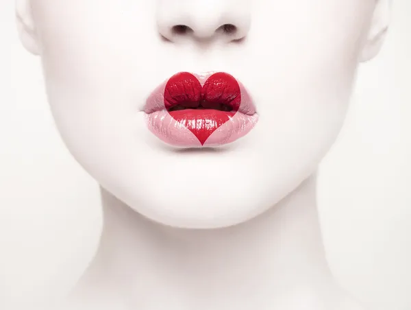 Retrato creativo de una hermosa joven con un corazón pintado en sus labios —  Fotos de Stock