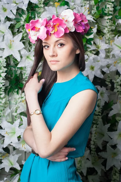 Mulher bonita e moda jovem perto da parede de flores — Fotografia de Stock