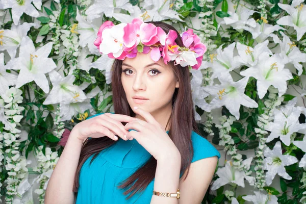 Mujer joven hermosa y de moda cerca de la pared de flores —  Fotos de Stock