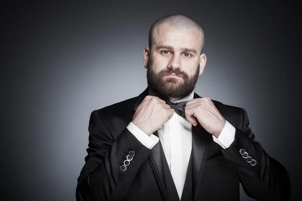 Uomo calvo elegante e brutale con la barba in elegante abito nero — Foto Stock