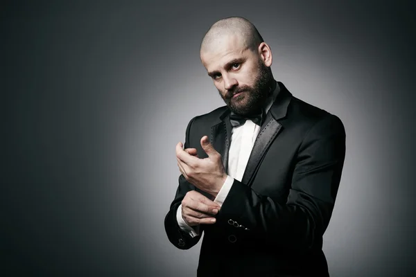 Stylish and brutal bald man with a beard  in elegant black suit — Stock Photo, Image