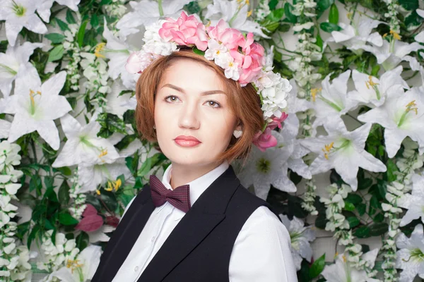 Mooie en mode jonge vrouw in de buurt van de muur van bloemen — Stockfoto