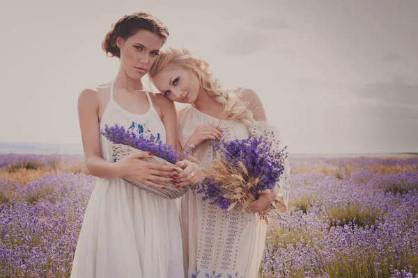 Retrato romántico de dos hermosas mujeres en el campo de lavanda —  Fotos de Stock