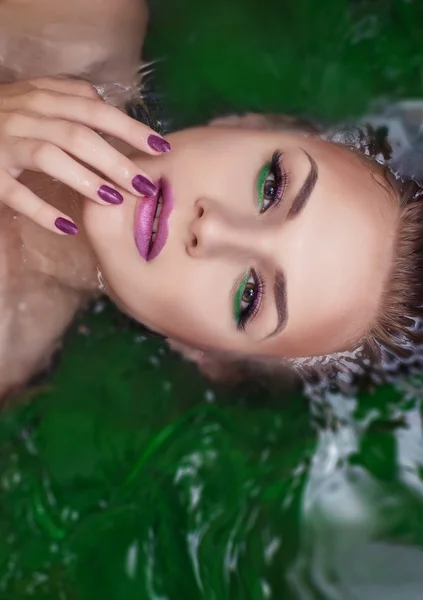 Mujer atractiva en el agua con glamour maquillaje — Foto de Stock