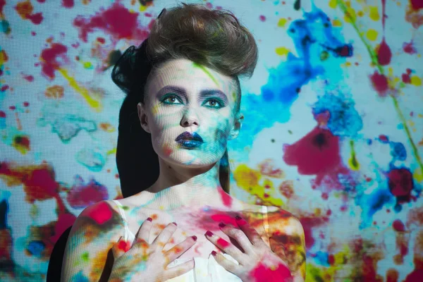 Retrato creativo, mujer de moda con imagen en color en su cara —  Fotos de Stock