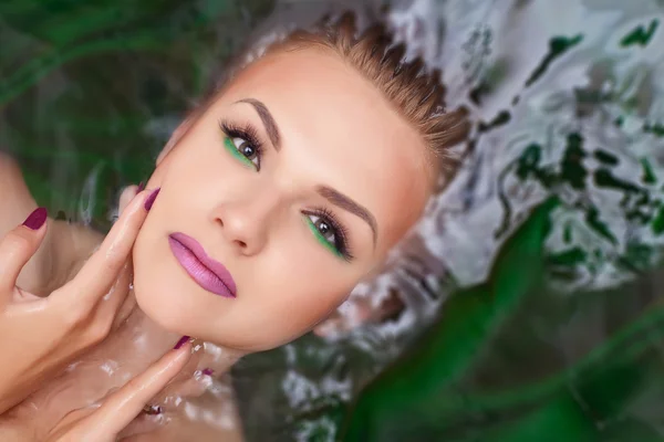 Femme attrayante dans l'eau avec maquillage glamour — Photo