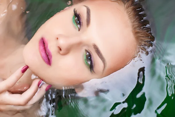 Femme attrayante dans l'eau avec maquillage glamour — Photo