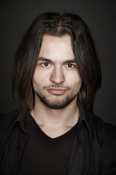 Closeup portrait of a stylish young man with long hair, studio shoot — Stock Photo, Image