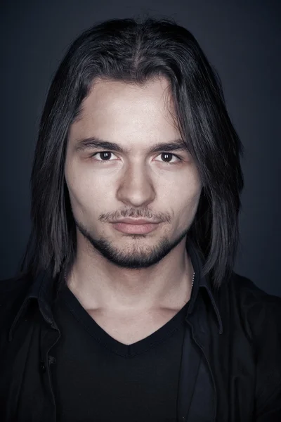 Primer plano retrato de un joven con estilo con el pelo largo, sesión de estudio —  Fotos de Stock