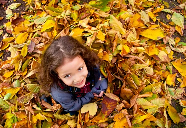 Klein meisje spelen met Herfstbladeren — Stockfoto