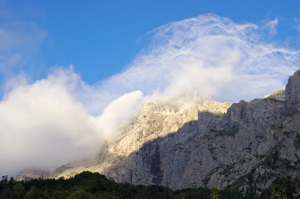 Bulutların içine sabahın erken saatlerinde sochi yakınındaki dağ tepe fisht — Stok fotoğraf