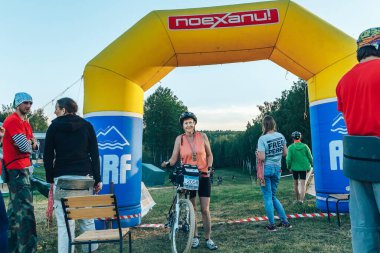 May 26-27, 2018 Naliboki,Belarus All-Belarusian amateur marathon Naliboki. An elderly female cyclist with her bike stands after the finish of the marathon