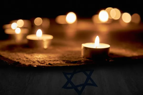Kaarsen branden over de ster van David ter nagedachtenis aan de doden. Een symbool van de herdenking van de slachtoffers van de genocide van de Jood — Stockfoto