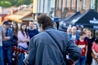 June 1, 2019 Minsk Belarus A rock musician plays guitar at a street concert.Young people listen to the concert of the guitarist