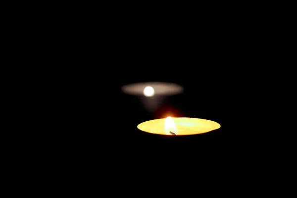 Dos velas encendidas en la mesa en honor a la conmemoración en la oscuridad —  Fotos de Stock