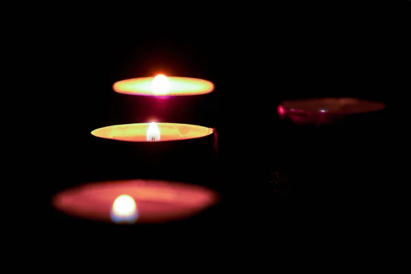 Kerzen im Dunkeln mit weicher, selektiver Fokussierung und Bokeh.Brennende Kerzen auf dem Tisch zu Ehren des Gedenkens im Dunkeln. — Stockfoto