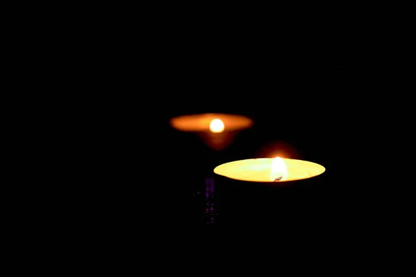 Круглые Свечи Две Зажжённые Свечи Светятся Тёмном Фоне — стоковое фото