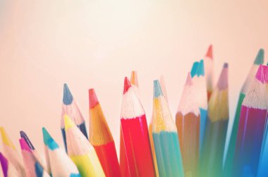 Beyaz arka plan üzerinde renkli kalemler yığını