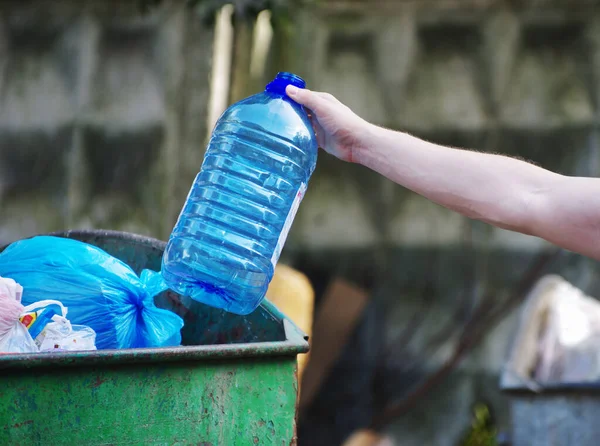 人们把垃圾瓶 塑料和玻璃杯放进垃圾袋里进行清洁 — 图库照片