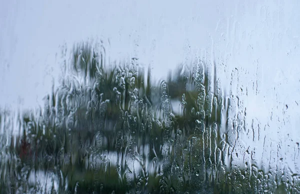 雨はボケを背景に窓ガラス面に落ちる — ストック写真