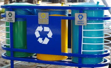 Atık için üç çok renkli geri dönüşüm kutusu ve çöp atıklarını ayırmak için simgeler.