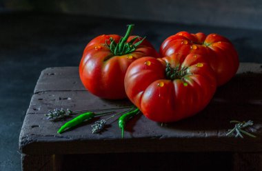 Domatesler siyah arkaplanda doğal ışıkta çekilir