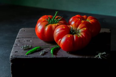 Domatesler siyah arkaplanda doğal ışıkta çekilir