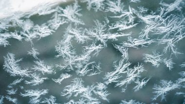 Kışın soğuk aylarında pencerede kar kristalleri oluştu.