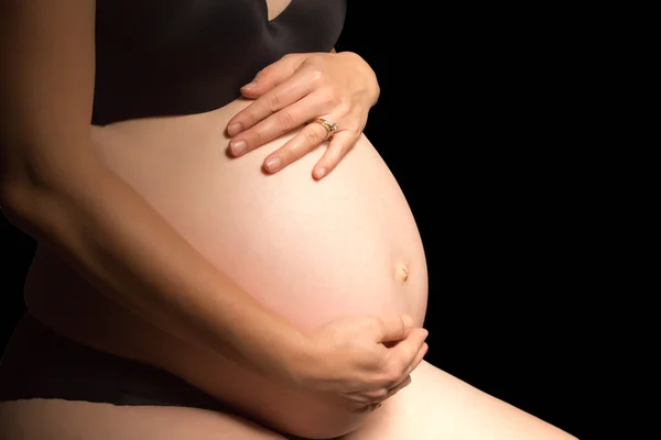 Gravid kvinna som håller magen Stockbild