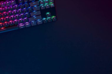 Gökkuşağı renkleri çalışma alanının köşesindeki bilgisayar klavyesini aydınlattı. Profesyonel bilgisayar oyunu, esport işi ve online dünya konsepti.