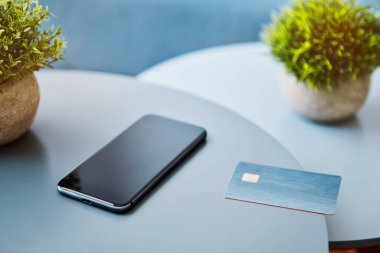 Cep telefonu ve elektronik çip kartı yuvarlak masada duruyordu. Modern teknoloji, kablosuz aygıt ve enerji aktarımı.