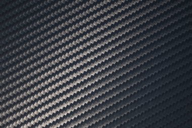 Örülmüş karbon fiber çarşaf yüzeyi. Doku ve şablonun çapraz yönelimi. Modern teknoloji ve malzeme konsepti