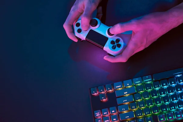 男性の手は コンピュータを制御するためのコントローラを使用して 虹色のバックライトゲームコンピュータのキーボード プロのコンピュータゲームプレイ スポーツビジネスとオンライン世界の概念 — ストック写真