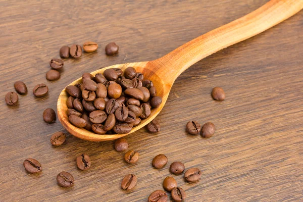 Cucchiaio di legno con chicchi di caffè — Foto Stock