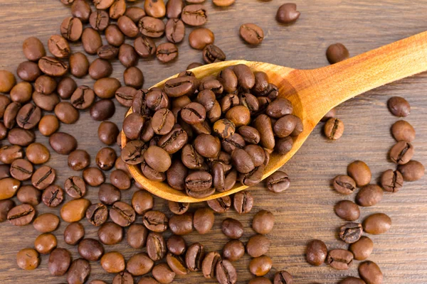 木製の背景にコーヒー豆のスプーン — ストック写真