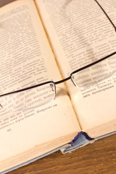 Glasses lying on retro book — Stock Photo, Image