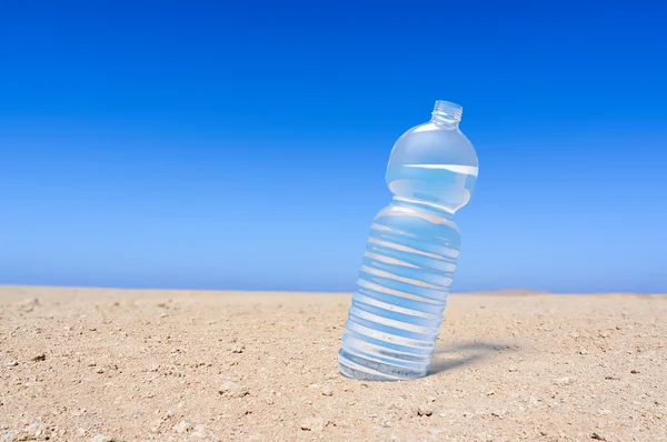 Бутылка воды в пустыне — стоковое фото