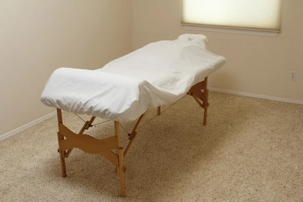 Mesa de massagem em uma sala de tratamento — Fotografia de Stock