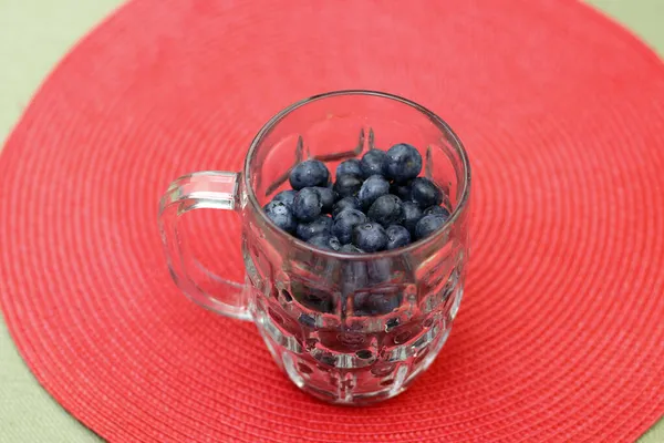 Large Organic Blueberry Fruit Clear Glass Cup Red Place Mat — Stock Photo, Image