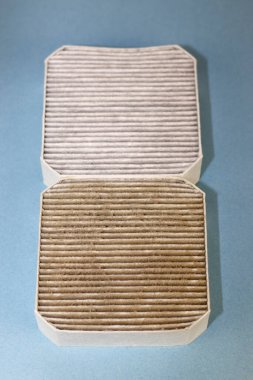 Two small square air filters that are also pre-filters, one dirty closer to viewer and one clean on a light blue background. One dirty air filter filled with dust, allergens and dirt under a clean one